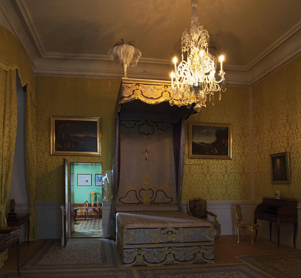 Спальня герцогини с реконструированной кроватью. Освещение имитирует степень сумерек, образуемых светом свечей.